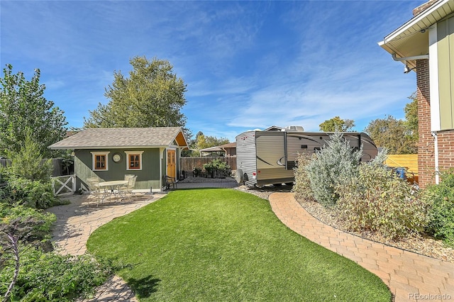 view of yard featuring a patio and an outbuilding