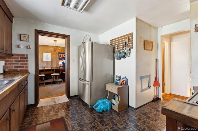 kitchen with stainless steel fridge and wooden walls