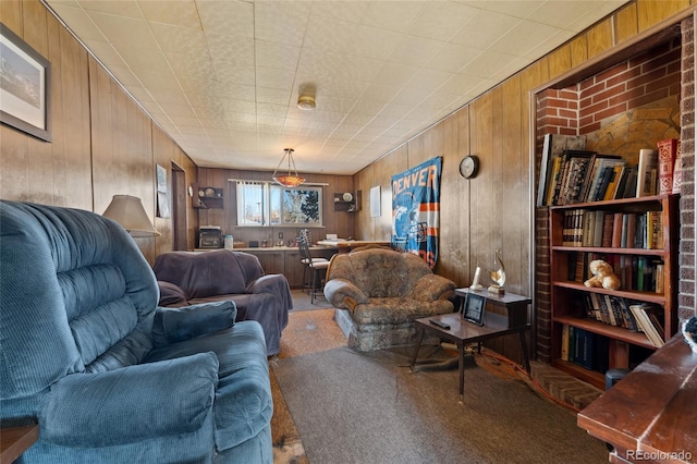 carpeted living room featuring wooden walls