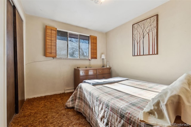 carpeted bedroom with a baseboard radiator and a closet