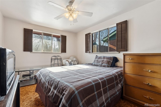 bedroom featuring ceiling fan and dark colored carpet