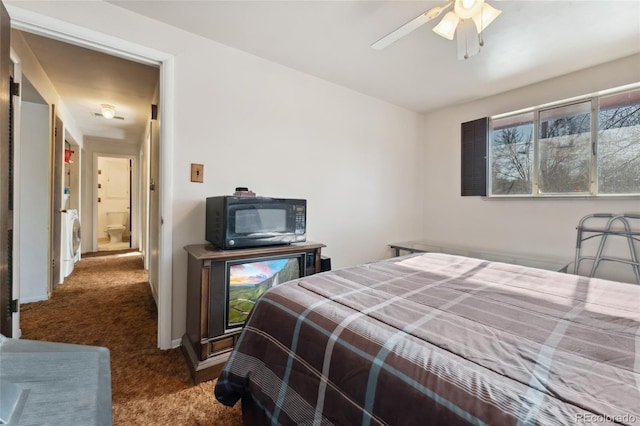 carpeted bedroom featuring washer / dryer and ceiling fan