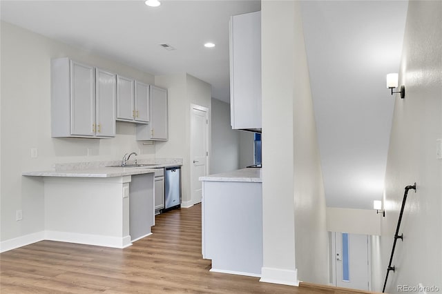 1285 W 9th Ave, Denver, CO 80204 - kitchen with stainless steel dishwasher, a sink, light countertops, recessed lighting, and light wood finished floors
