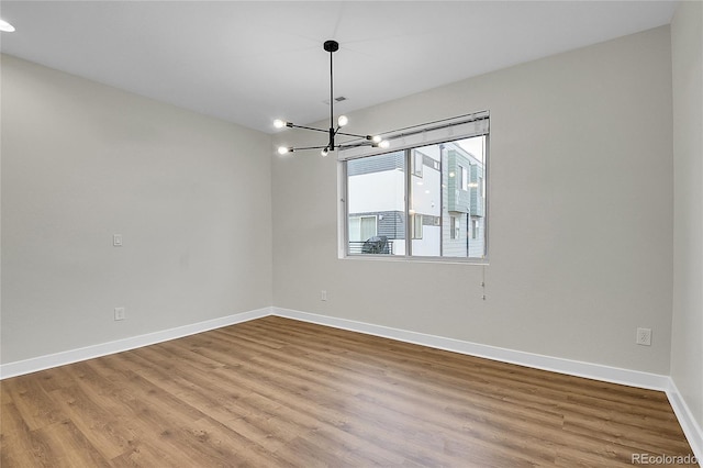 1285 W 9th Ave, Denver, CO 80204 - spare room featuring wood finished floors, baseboards, and a chandelier