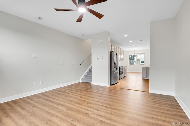 1285 W 9th Ave, Denver, CO 80204 - unfurnished living room with stairs, light wood-style flooring, ceiling fan, baseboards, and recessed lighting
