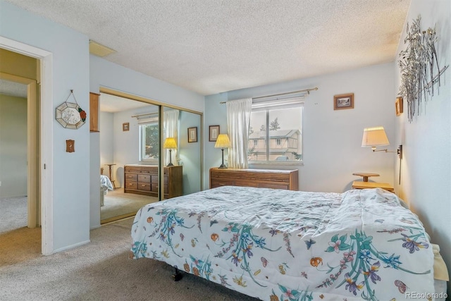 carpeted bedroom with visible vents, a closet, and a textured ceiling