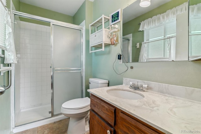 bathroom with toilet, a stall shower, and vanity