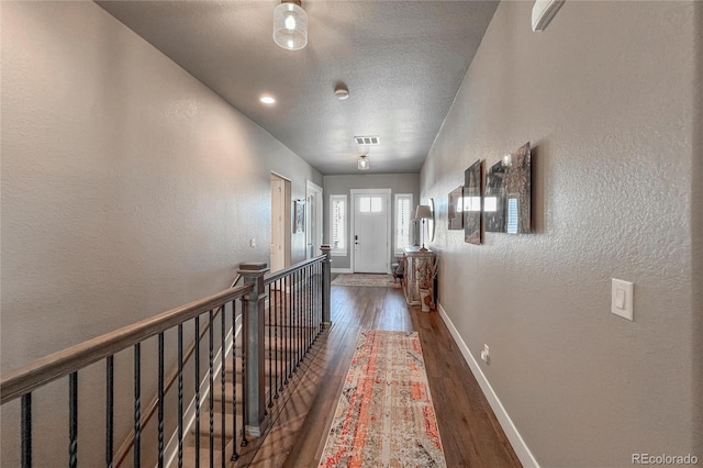 hallway featuring a textured ceiling and dark wood-type flooring