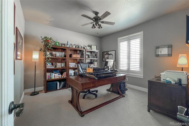 carpeted office space featuring ceiling fan and a textured ceiling