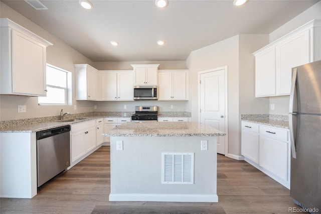 kitchen with white cabinetry, a kitchen island, and appliances with stainless steel finishes