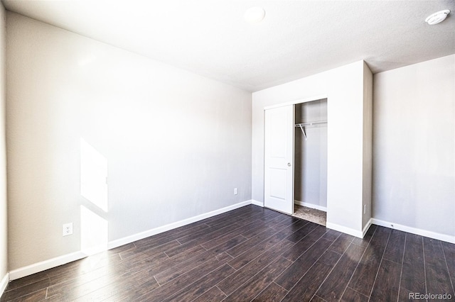 unfurnished bedroom featuring dark hardwood / wood-style flooring and a closet