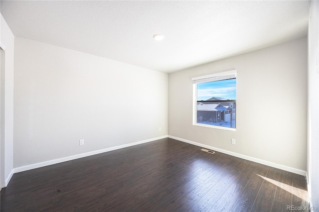 spare room with dark hardwood / wood-style floors