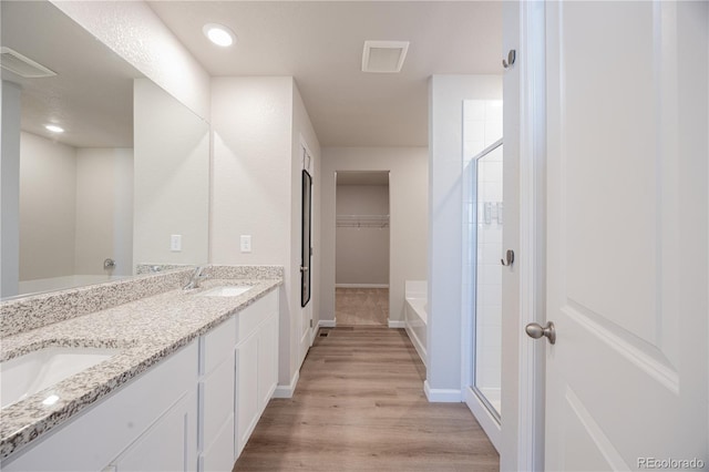 bathroom with hardwood / wood-style flooring, vanity, and independent shower and bath