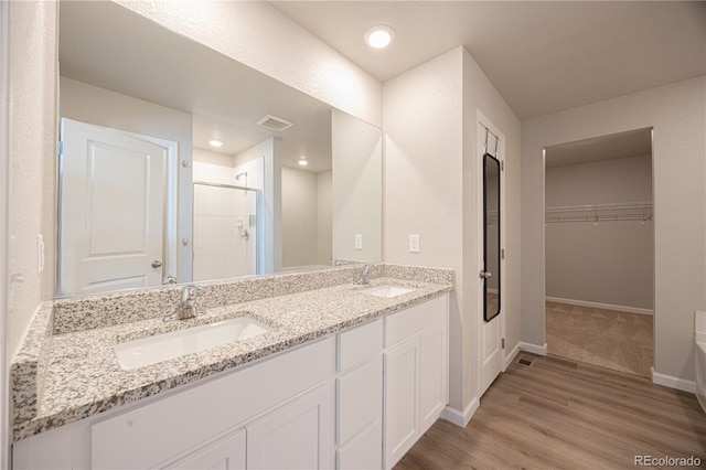 bathroom featuring hardwood / wood-style flooring, vanity, and an enclosed shower