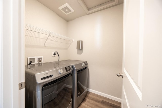 laundry area featuring washer and clothes dryer and light hardwood / wood-style flooring