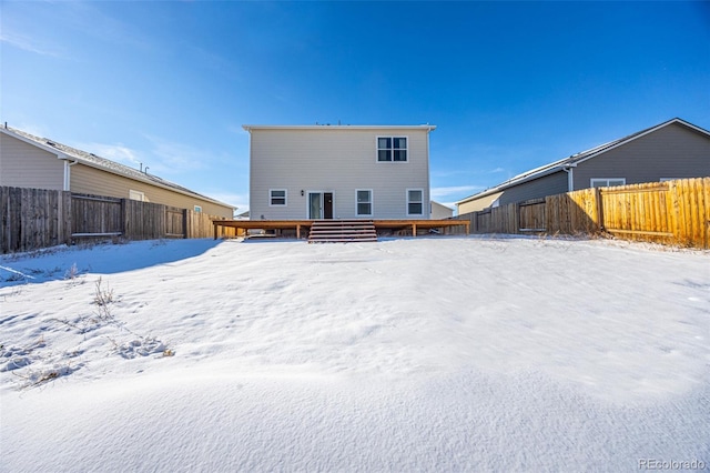 snow covered back of property featuring a wooden deck