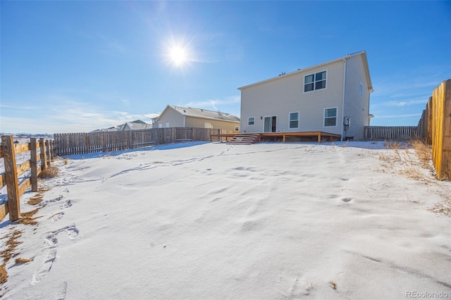 snow covered house featuring a wooden deck