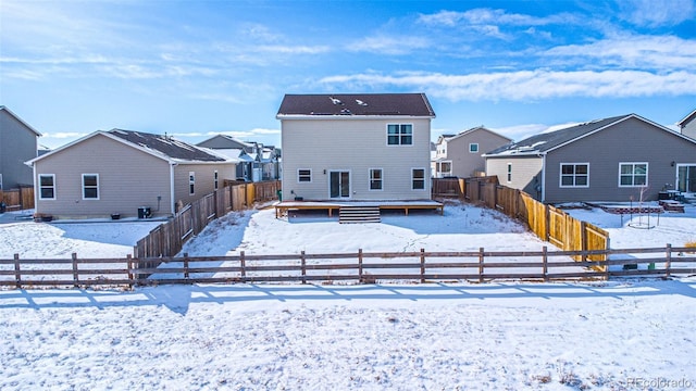 view of snow covered back of property