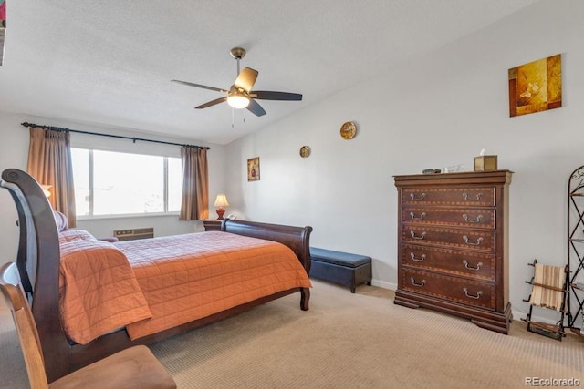 bedroom featuring ceiling fan, light colored carpet, and a textured ceiling