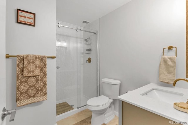 bathroom featuring vanity, a shower with door, and toilet