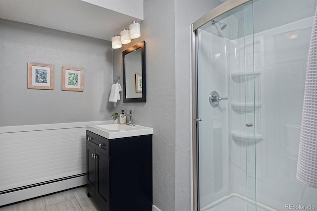 bathroom featuring a baseboard radiator, vanity, and a stall shower