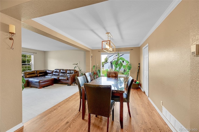 106 Cherry St, Castle Rock, CO 80104 - dining area with light wood finished floors, a textured wall, ornamental molding, and a chandelier