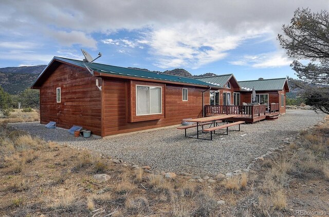 rear view of property with a deck with mountain view