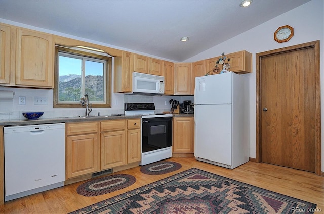 kitchen with lofted ceiling, sink, white appliances, and light hardwood / wood-style floors