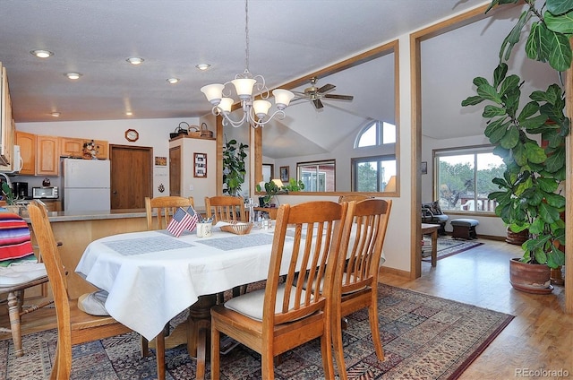 dining room featuring vaulted ceiling, a chandelier, a textured ceiling, and light wood-type flooring