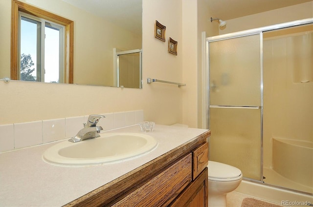 bathroom featuring vanity, toilet, and an enclosed shower