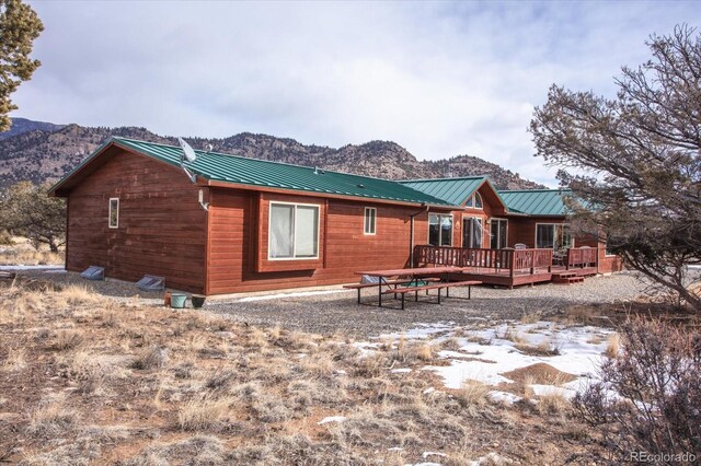 rear view of house featuring a deck with mountain view