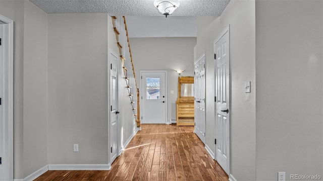 corridor with hardwood / wood-style flooring and a textured ceiling