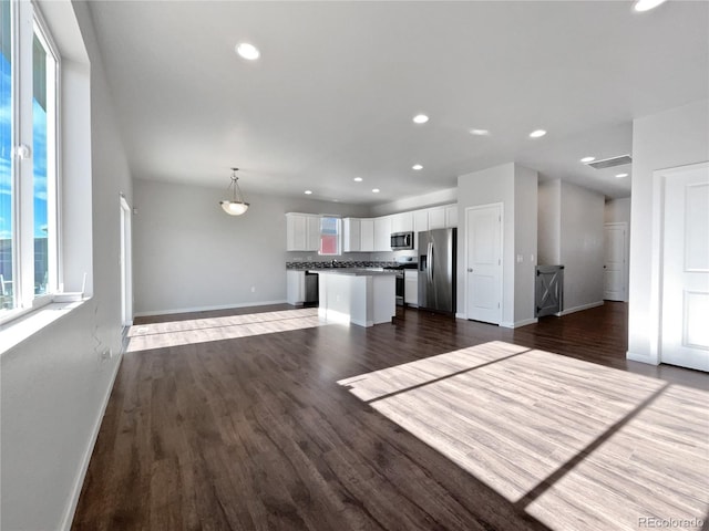 kitchen featuring decorative light fixtures, dark hardwood / wood-style floors, a center island, stainless steel appliances, and white cabinets