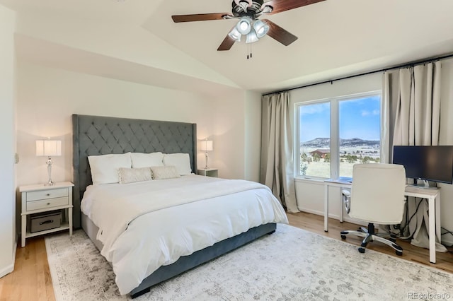 bedroom featuring vaulted ceiling, a ceiling fan, and light wood-style floors