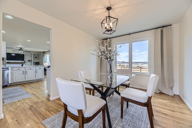 dining area with ceiling fan with notable chandelier, recessed lighting, light wood-style flooring, and baseboards