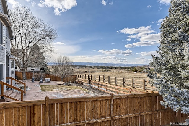 view of yard with fence private yard, a patio area, a mountain view, and a rural view