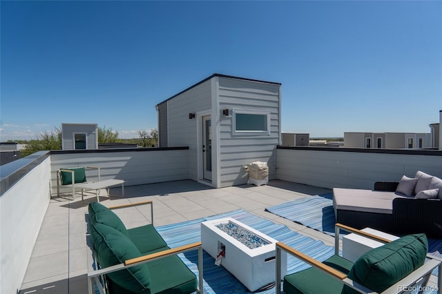 view of patio / terrace with a balcony and an outdoor living space with a fire pit