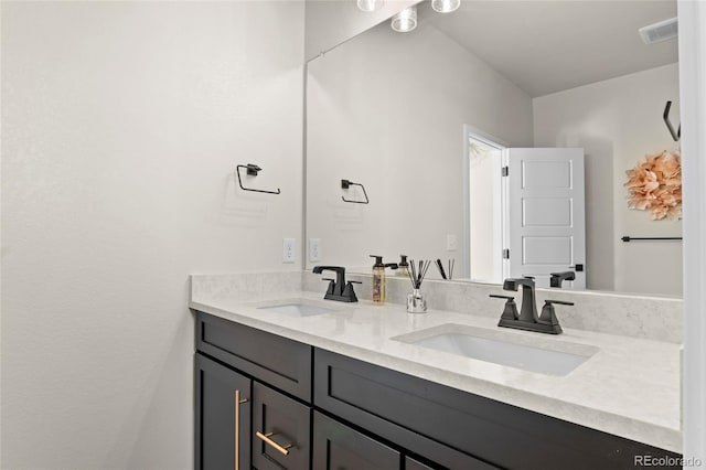 bathroom with double vanity, visible vents, and a sink