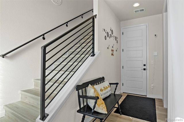 foyer entrance featuring recessed lighting, baseboards, wood finished floors, visible vents, and stairway