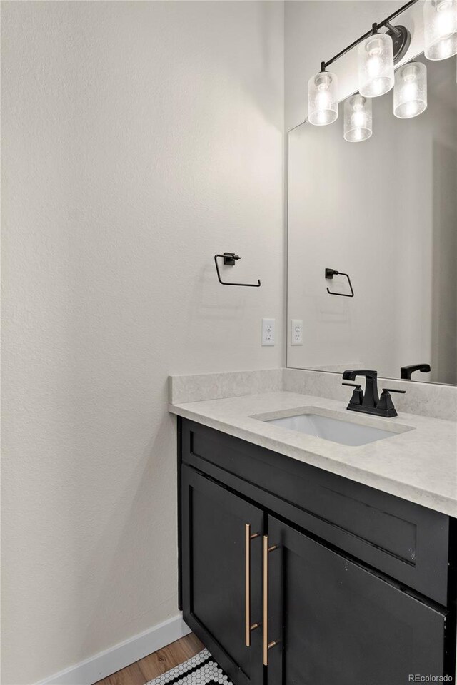 bathroom featuring vanity, baseboards, and wood finished floors