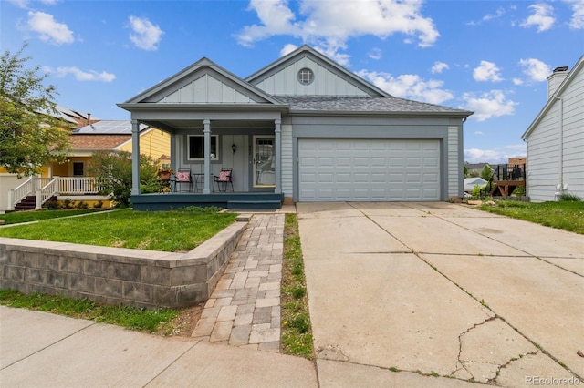 462 Chelan St, Golden, CO 80401 - ranch-style home with a porch, board and batten siding, an attached garage, driveway, and a front lawn