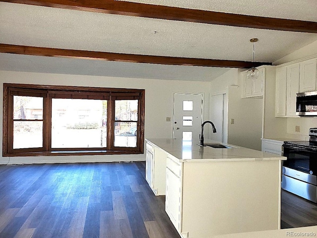 609 S 1st Ave, Brighton, CO 80601 - kitchen with stainless steel appliances, a sink, beamed ceiling, white cabinets, and dark wood-style flooring