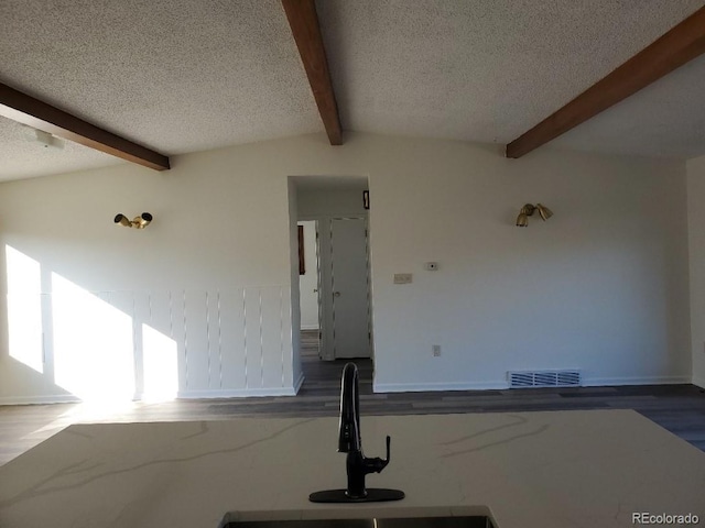 609 S 1st Ave, Brighton, CO 80601 - unfurnished living room with a textured ceiling, wood finished floors, a wainscoted wall, and a sink