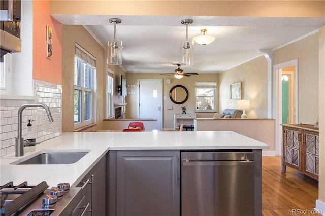 kitchen with tasteful backsplash, hanging light fixtures, sink, hardwood / wood-style flooring, and ceiling fan