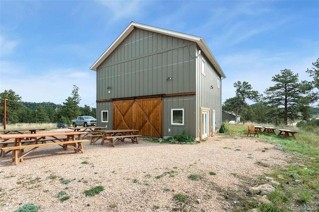 rear view of property with an outdoor structure