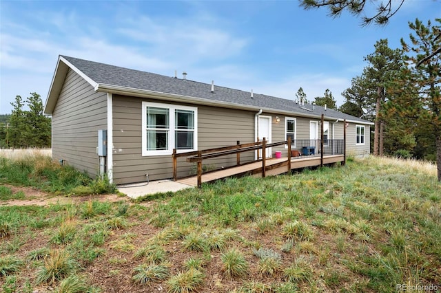 rear view of property featuring a deck