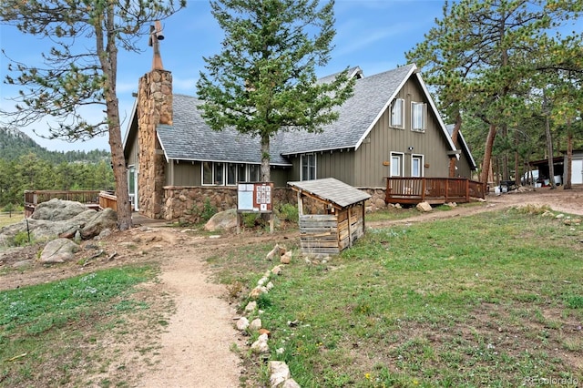 view of front of property with a wooden deck and a front yard