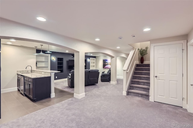 3525 Rinn Valley Dr, Longmont, CO 80504 - kitchen featuring light stone countertops, open floor plan, arched walkways, recessed lighting, and beverage cooler