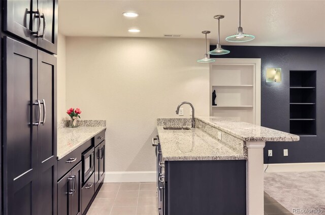 3525 Rinn Valley Dr, Longmont, CO 80504 - kitchen with a peninsula, light stone countertops, decorative light fixtures, a breakfast bar area, and built in microwave
