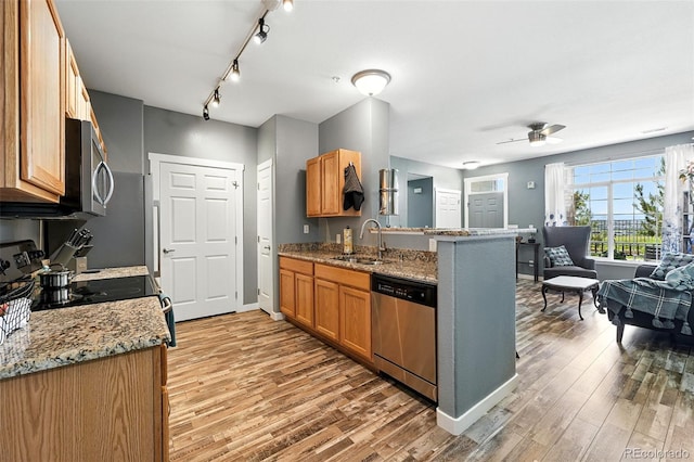 474 Black Feather Loop Unit 406, Castle Rock, CO 80104 - kitchen featuring appliances with stainless steel finishes, light wood-style flooring, a peninsula, ceiling fan, and light stone countertops